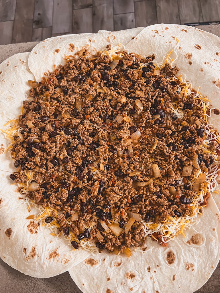 adding taco meat to quesadilla