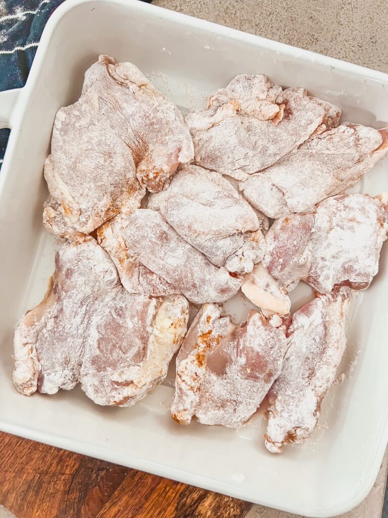 chicken thighs coated with flour in baking dish