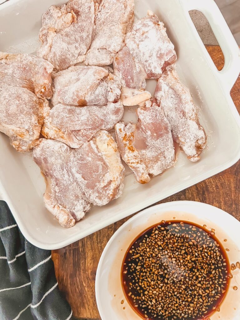 chicken thighs with flour along side the honey garlic sauce