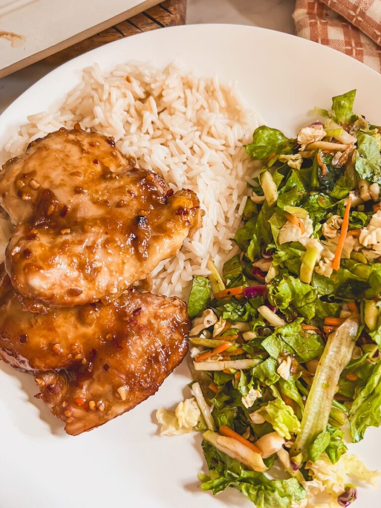 honey garlic chicken plated with rice and a side salad