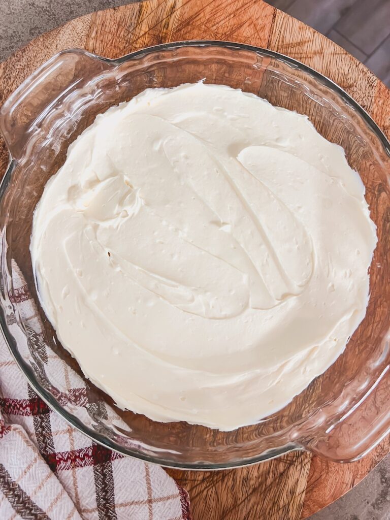 cream cheese mixture spread in glass pie dish