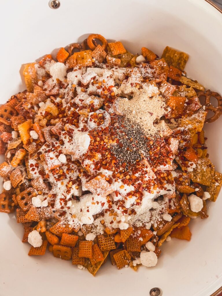 snack mix with seasoning added in white bowl