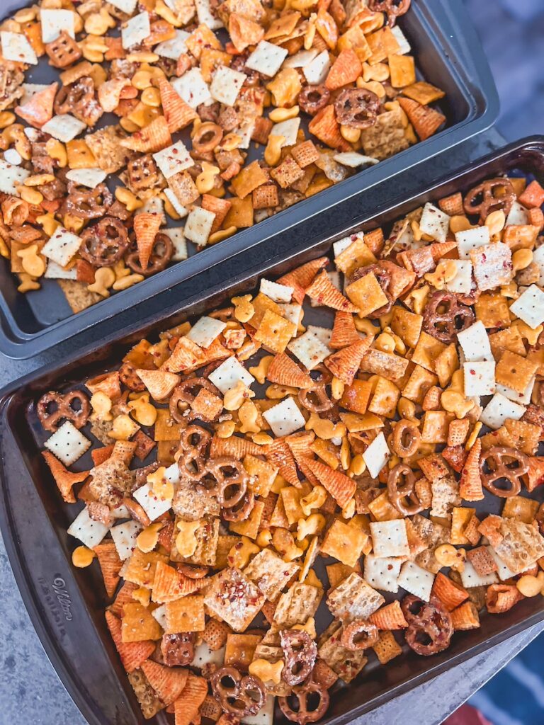snack mix layered on 2 baking sheets