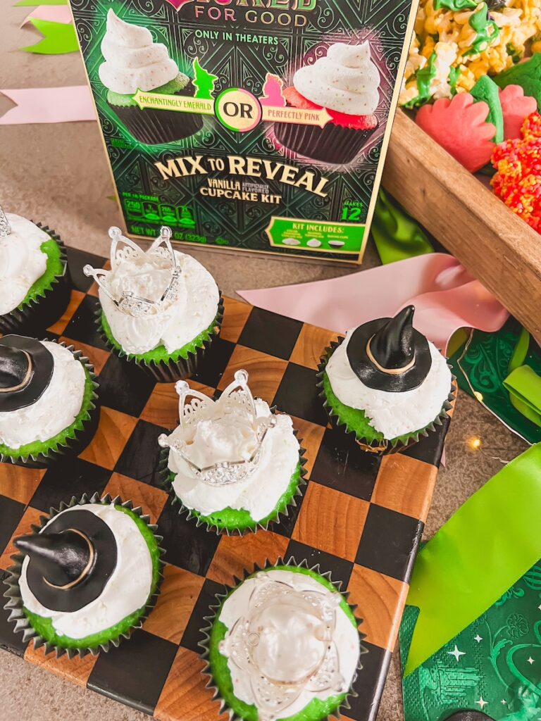 mix reveal cupcakes that are green topped with crown and witch hats