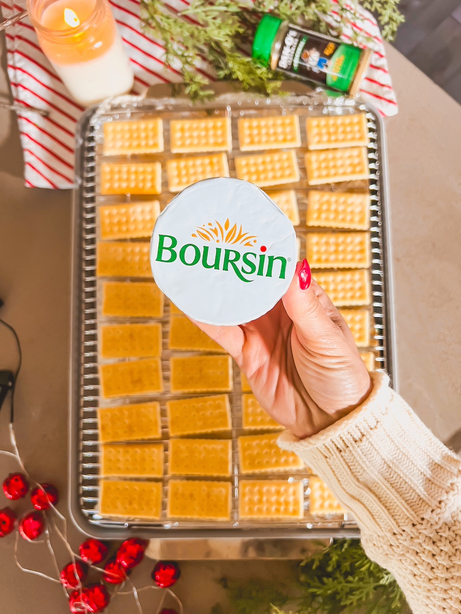 boursin cheese packet in hand with club crackers
