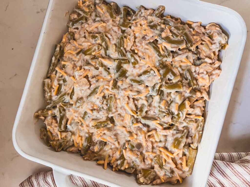 green bean casserole in a white baking dish ready to be baked
