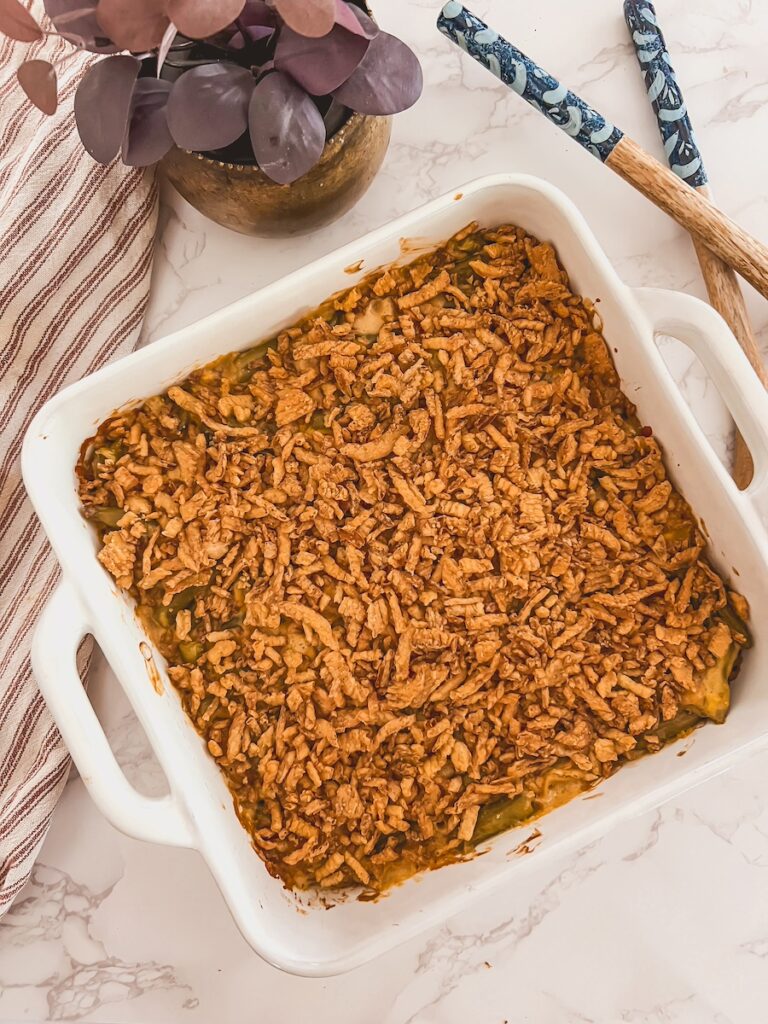 green bean casserole with crispy onions in a white baking dish