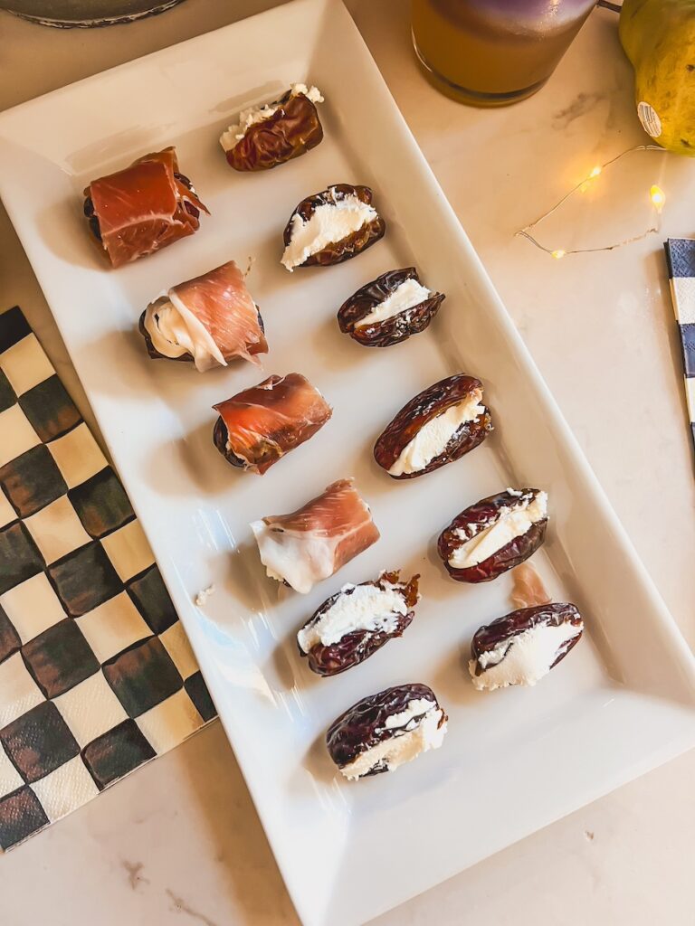 prosciutto wrapped dates on a white platter