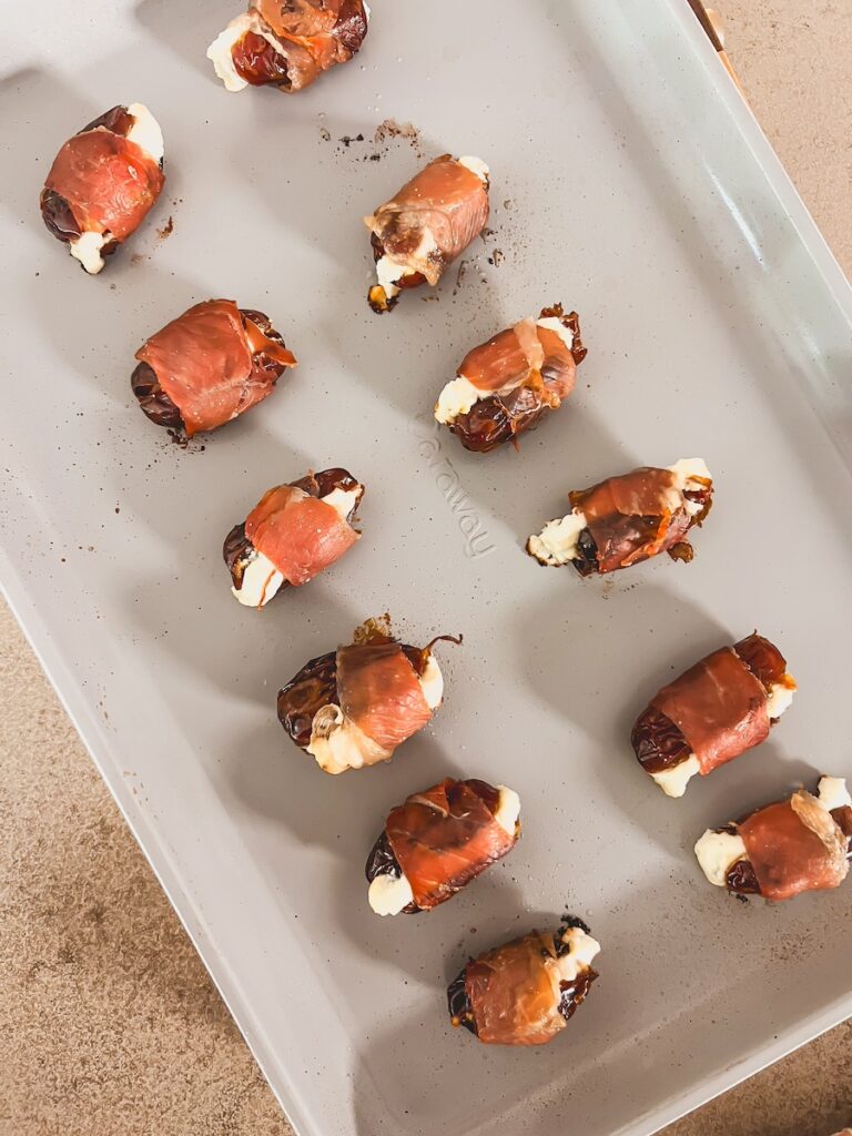 prosciutto wrapped dates out of the oven on a baking dish