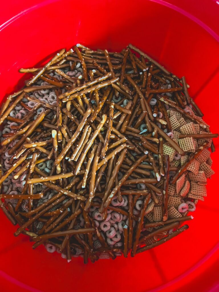 chex cereal , cheerios and pretzels in red bowl