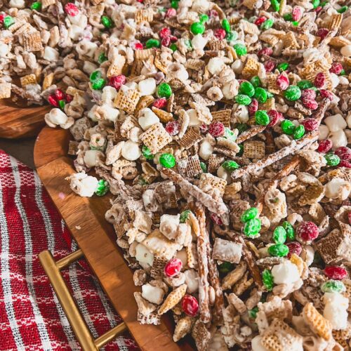 close up of christmas crack chex mix on wood board