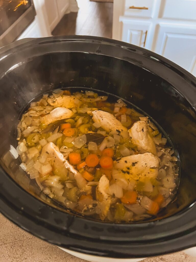 Cooked chicken and vegetables in a slow cooker.