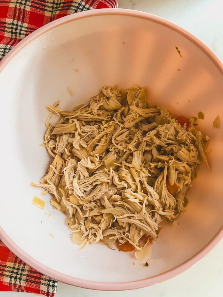 Shredded chicken in a white bowl.