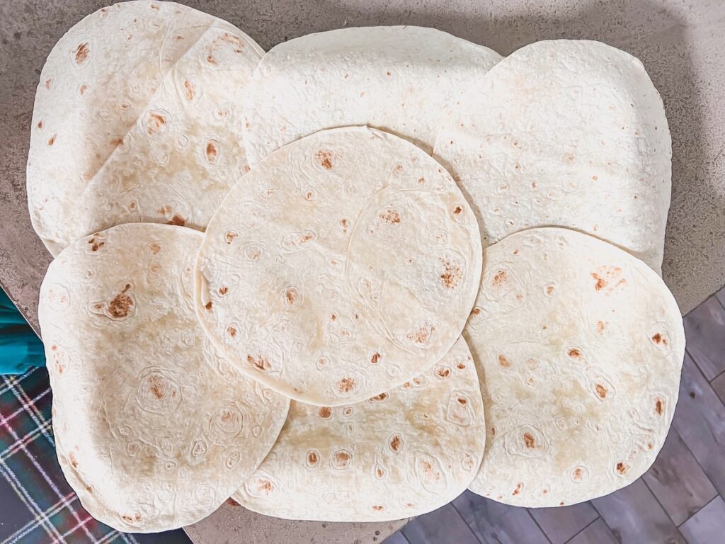 Flour tortillas overlapping on a sheet pan. 
