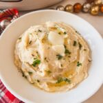 Cheesy garlic mashed potatoes in a white bowl.