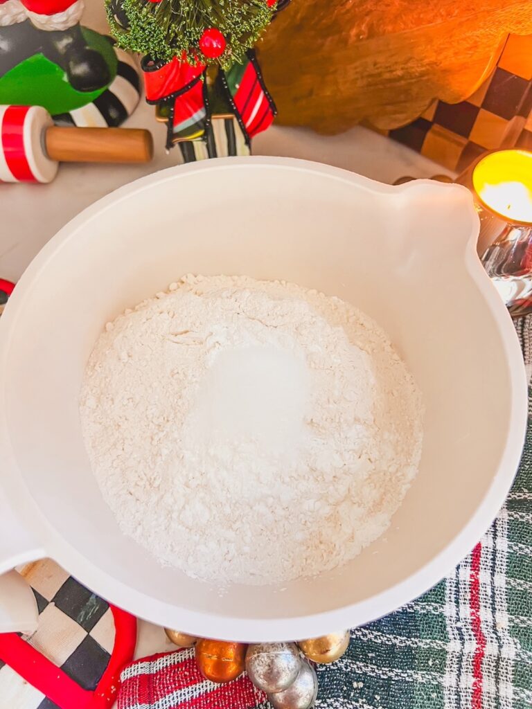 Dry ingredients added to the creamed butter and sugar in a white bowl. 