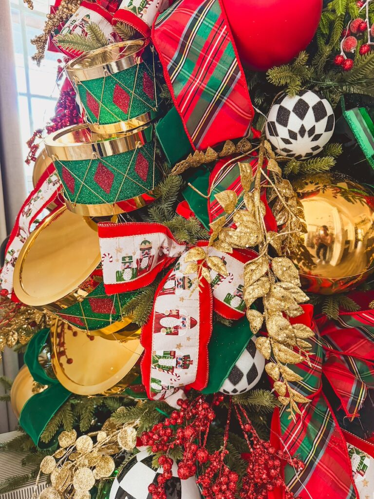 christmas nutcracker themed tree with red green and gold and cascading drums