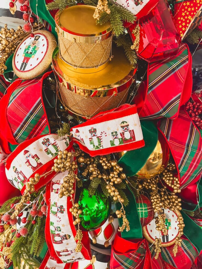 close up of christmas tree tartan plaid and nutcracker ribbon with gold drums