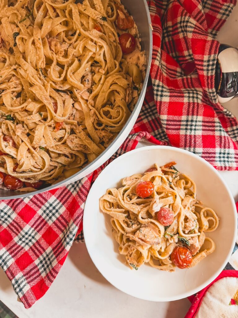 bowl of baked salmon pasta next to a baking dish