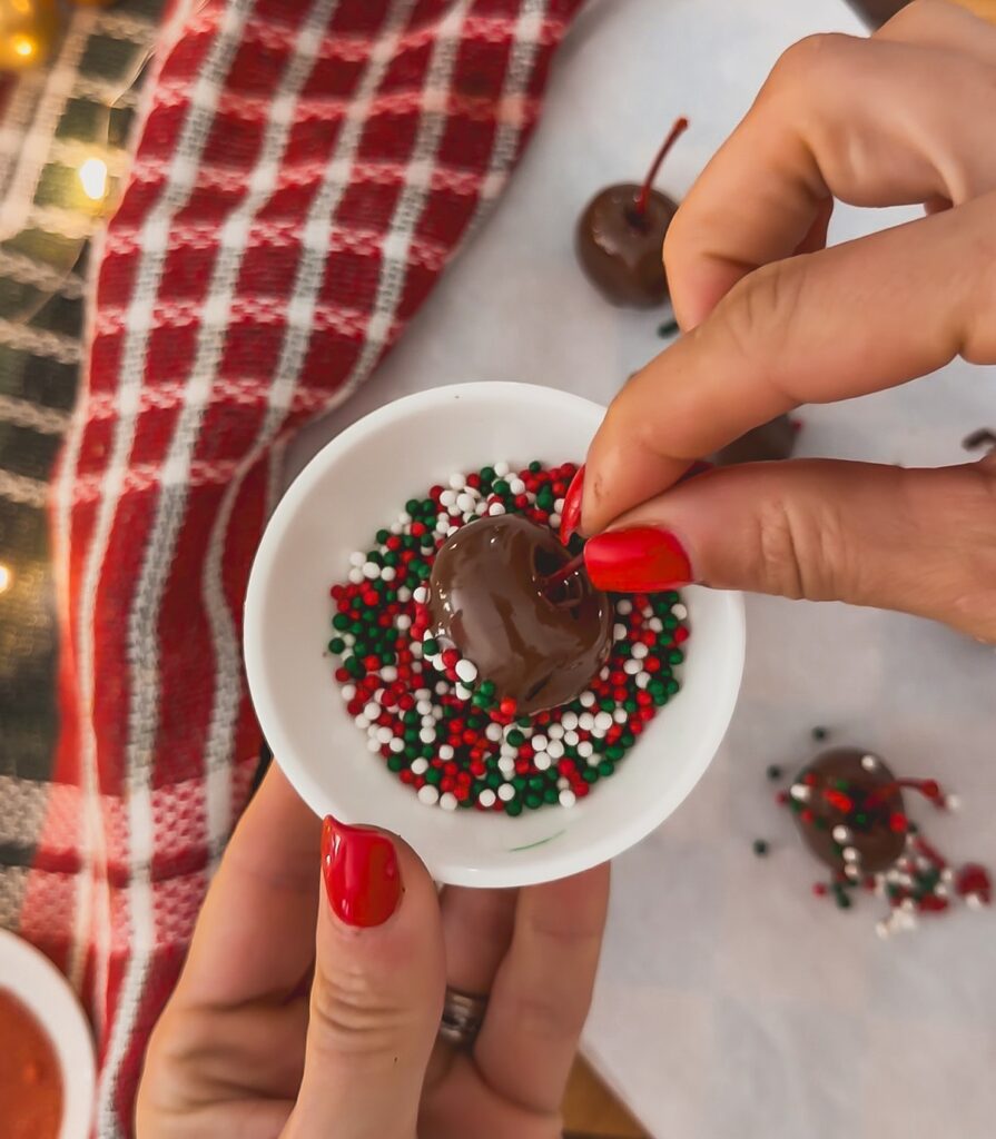 dipping cherry with chocolate in sprinkles