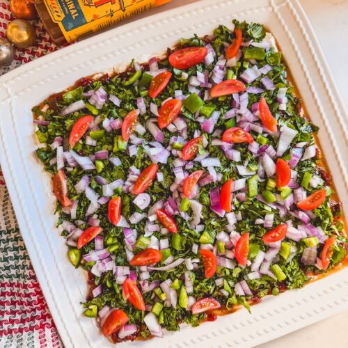 chipotle layered dip on a white serving platter