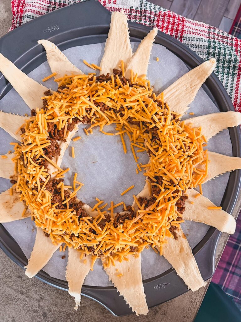 adding cheddar cheese on top of beef