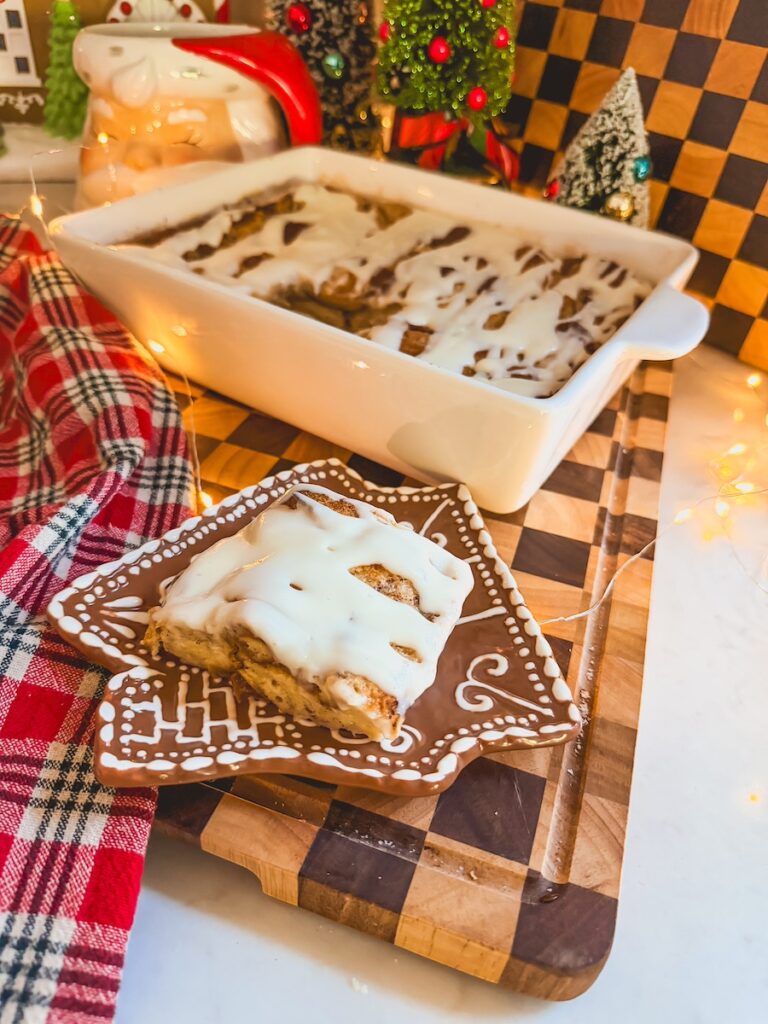 cinnamon roll bread pudding on a plate along side the baking dish