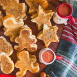 grilled cheese in holiday shapes with tomato soup on a board