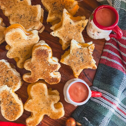 grilled cheese in holiday shapes with tomato soup on a board