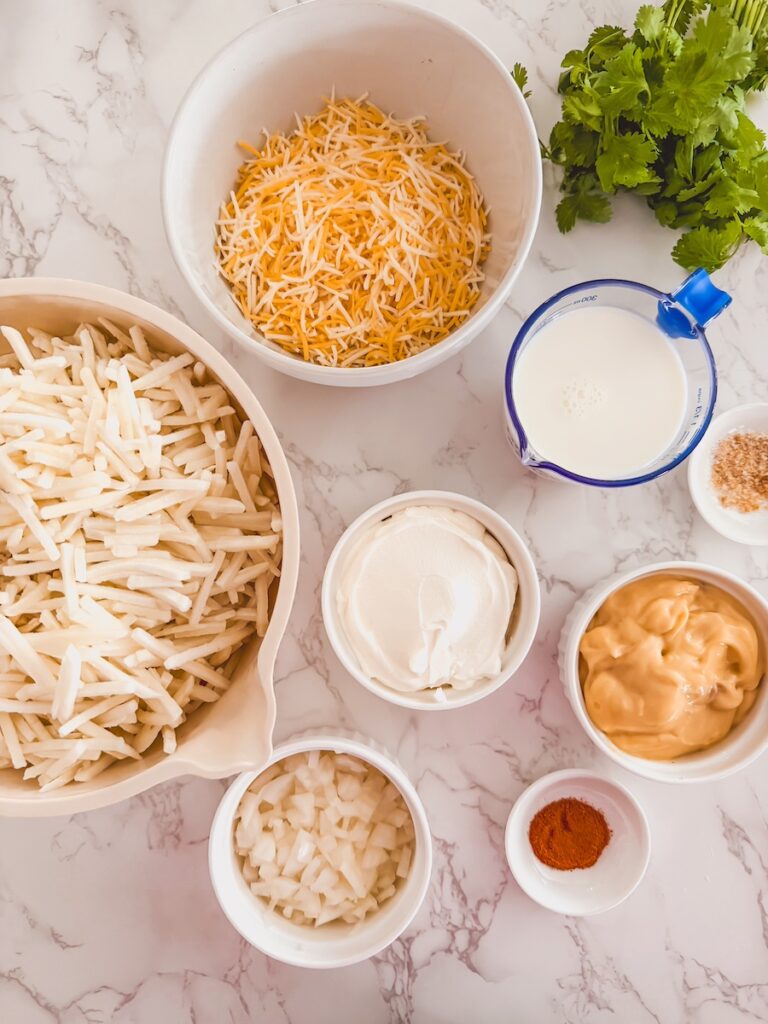slow cooker cheesy potatoes ingredients in bowls on marble counter