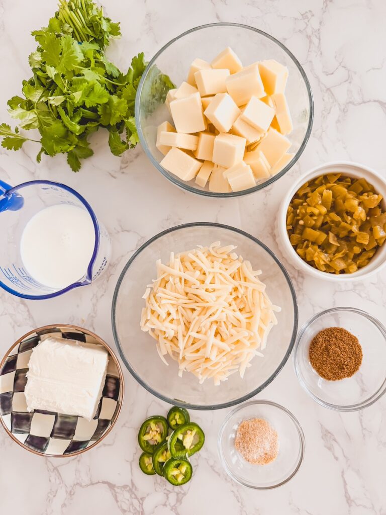 crock pot white queso ingredients on counter in glass bowls