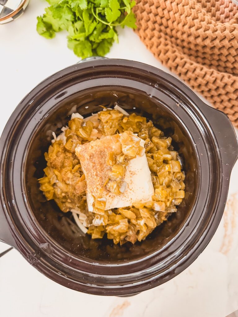 grated cheese, cream cheese, spices and canned green chiles in base of crock pot