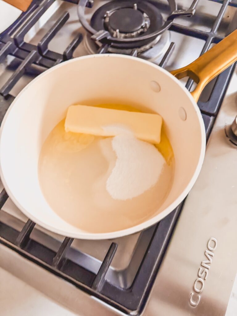 A saucepan on the stove with butter nad sugar melting.