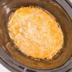 shredded hasbrowns, creamy sauce and cheese mixed together, cooking in slow cooker