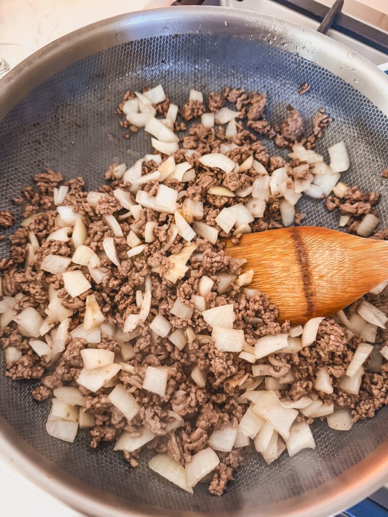 ground beef with sweet onion in skillet