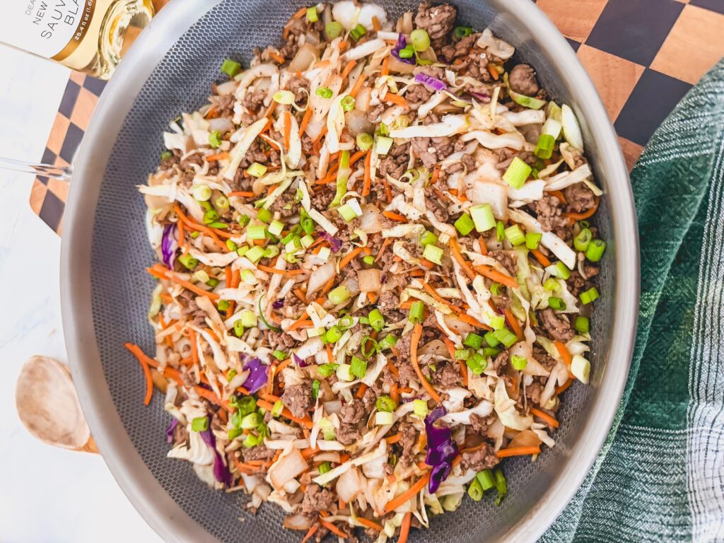 egg roll In a bowl topped with green onions in skillet