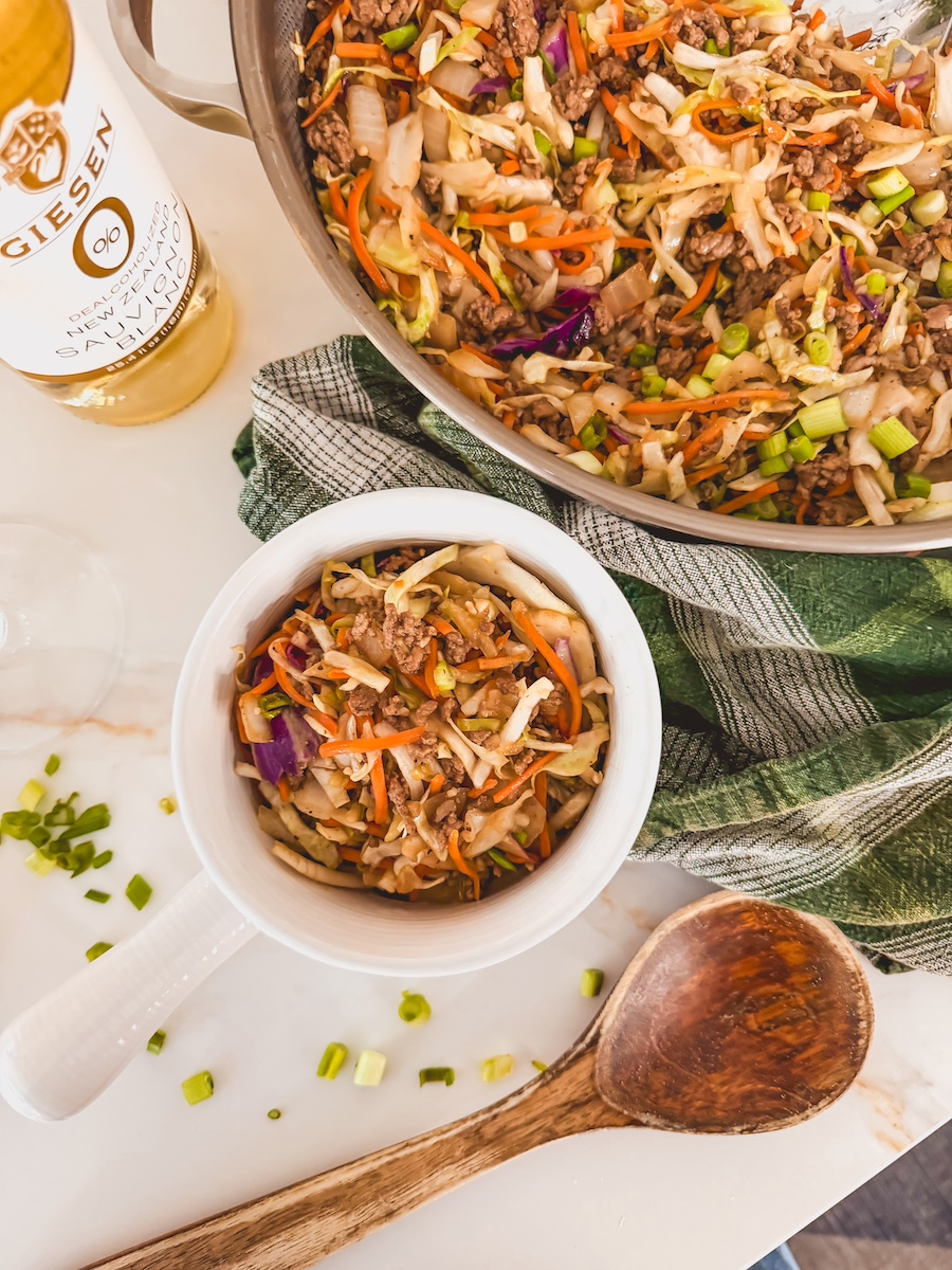 egg roll in a bowl overhead shot in a white bowl next to skillet