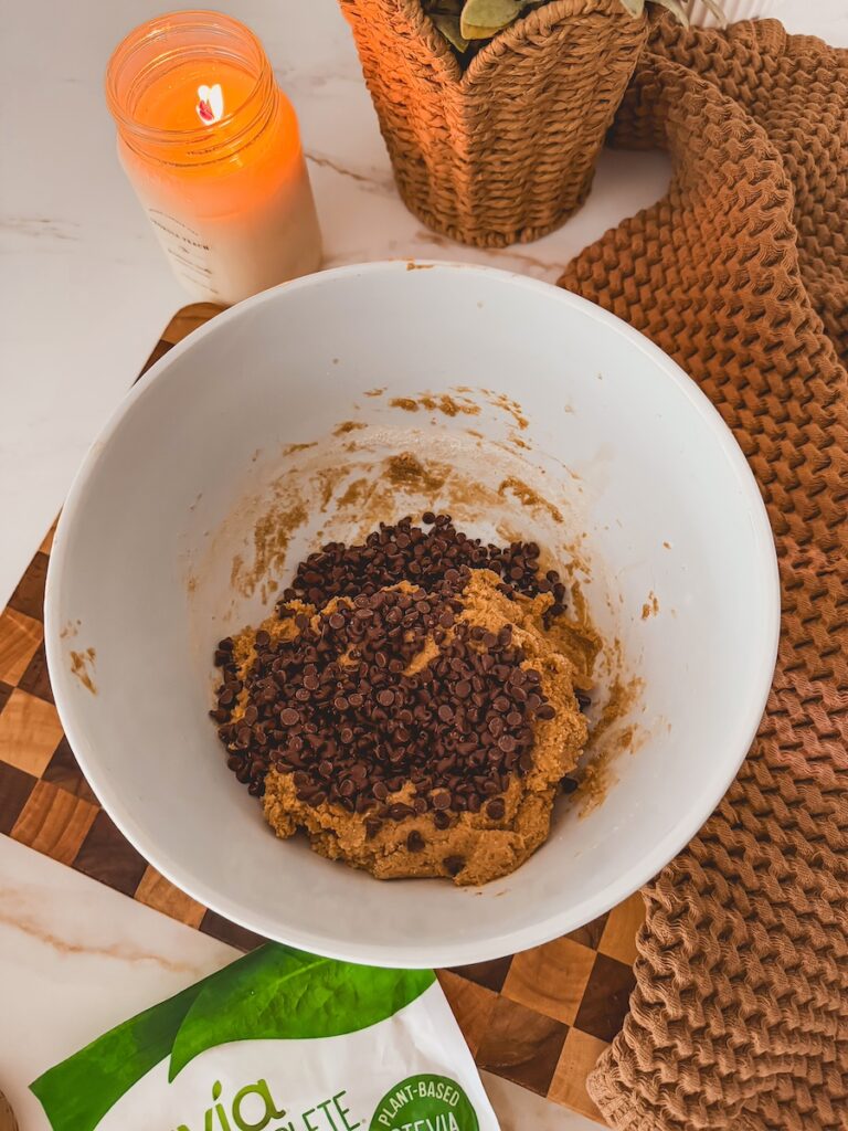 mini chocolate chips added to dough in white bowl