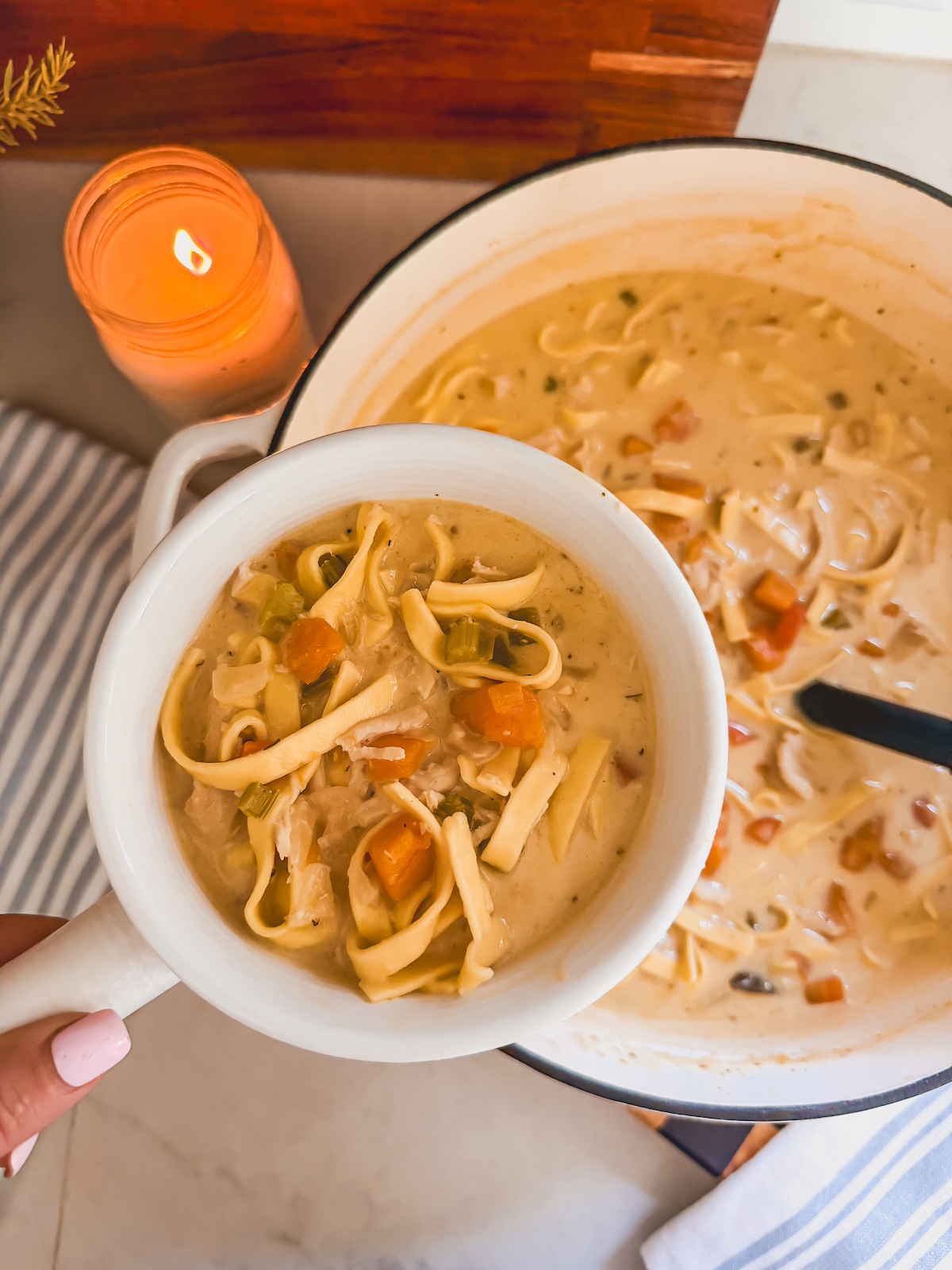 creamy chicken noodle soup in white bowl