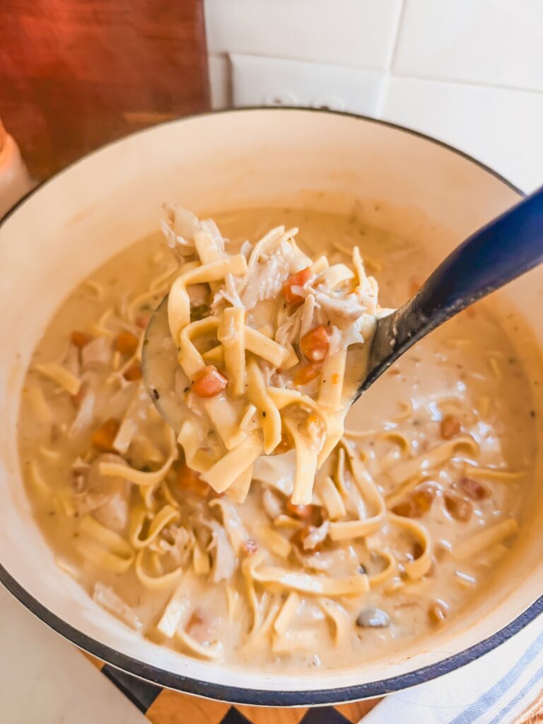 ladle of soup in white dutch oven