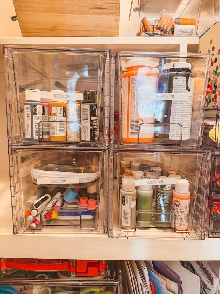 clear bins with paint and craft supplies