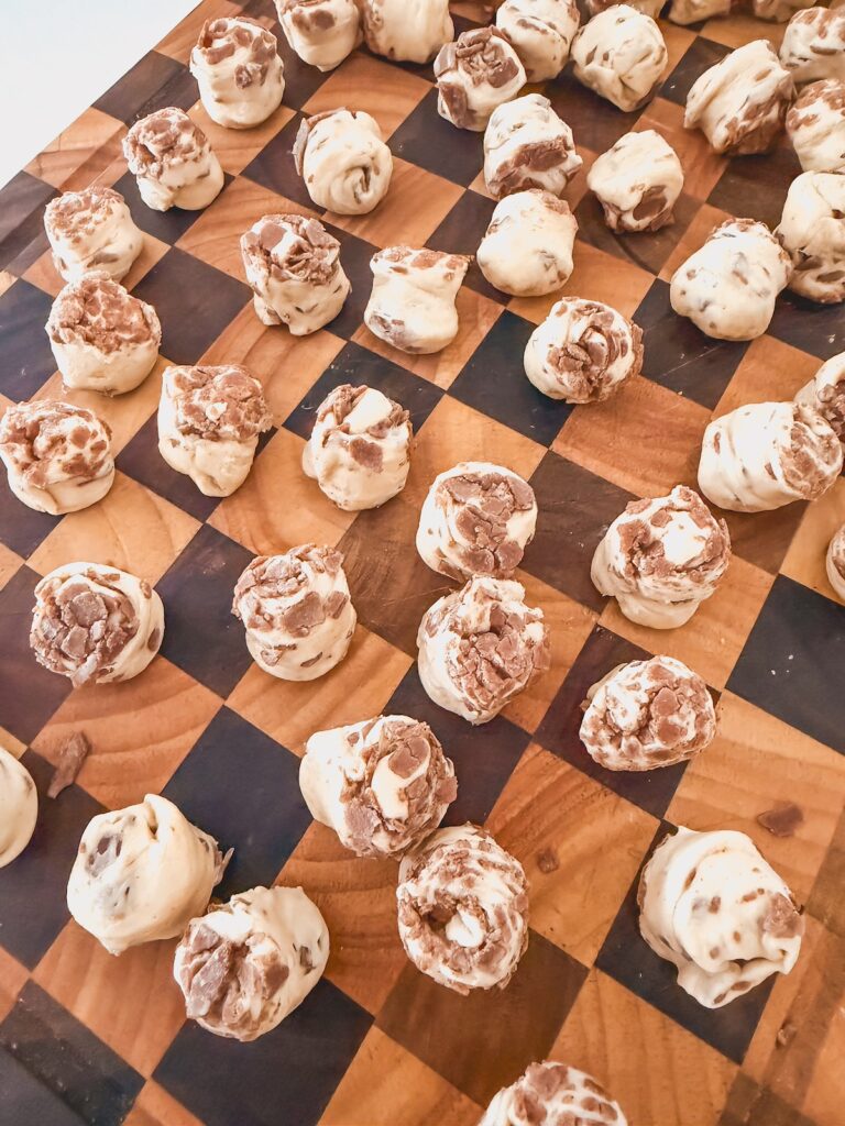 cinnamon rolls rolled into smaller pieces on wood board