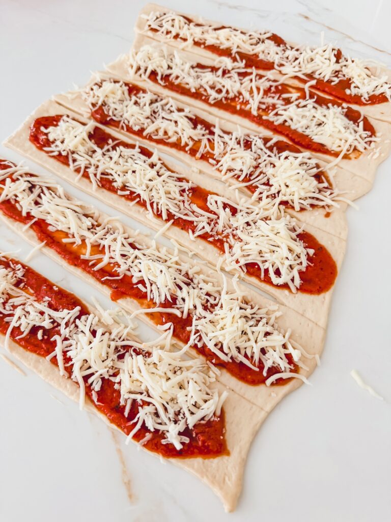 shredded mozarella on pizza dough