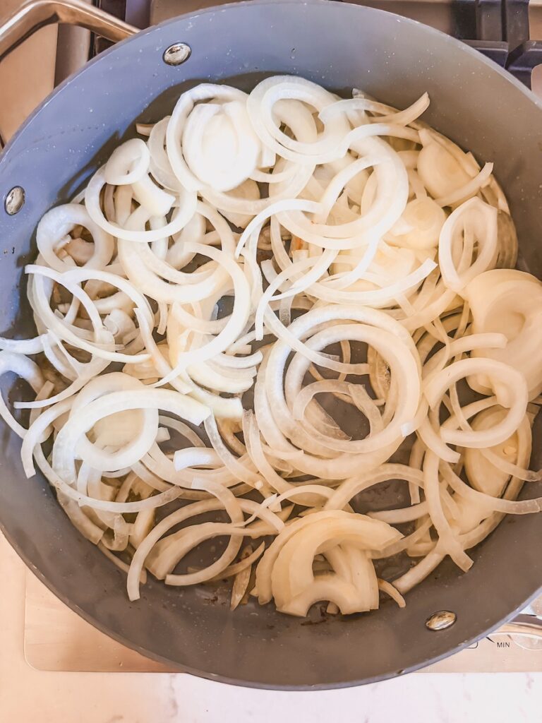 raw sliced onions in pan