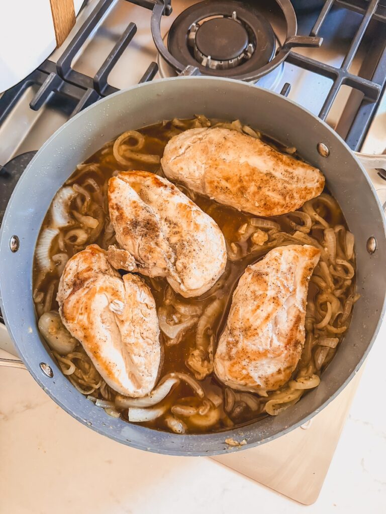 pan with caramelized onions, broth and chicken breasts