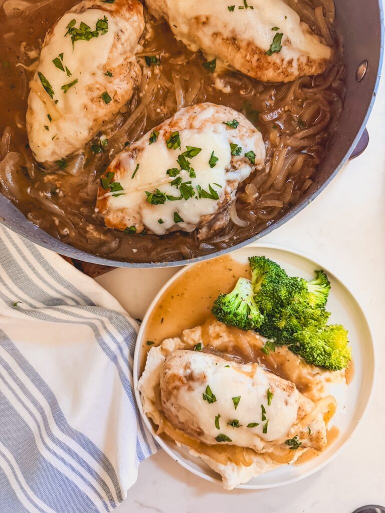 french onion chicken in pan with a plated serving next to it on a small white plate with broccoli and potatoes