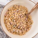 Ham pasta salad in serving bowl with serving utensil