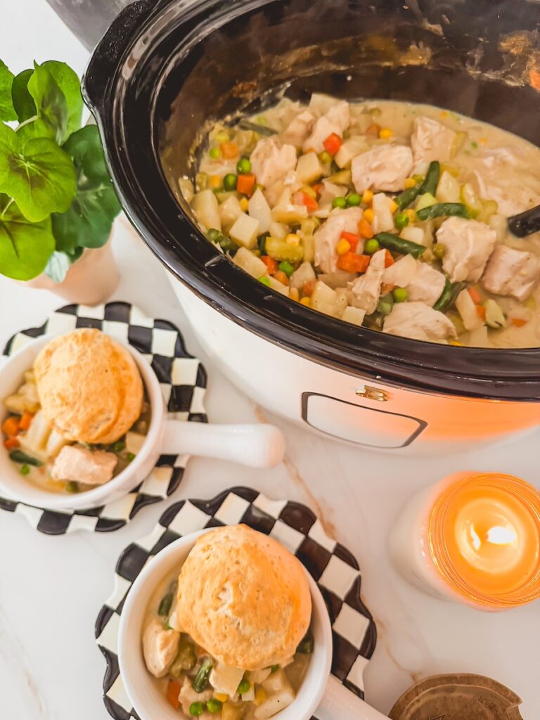 slow cooker chicken pot pie in slow cooker next to two individual servings of chicken pot pie topped with biscuits
