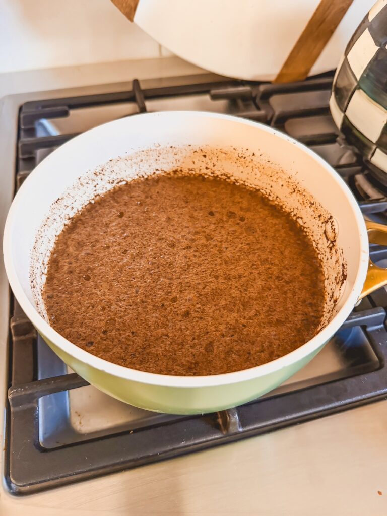 A white saucepan with ingredients for the coca cola glaze for slow cooker coca cola ham. 
