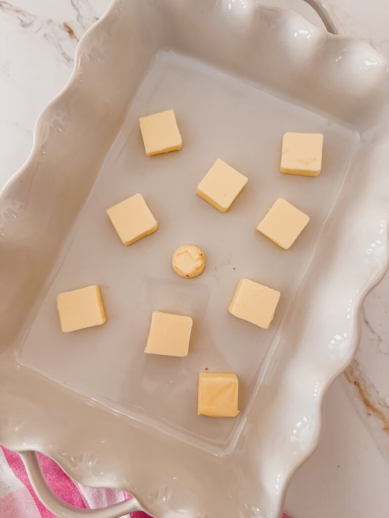 cubes of butter in bottom of white baking dish